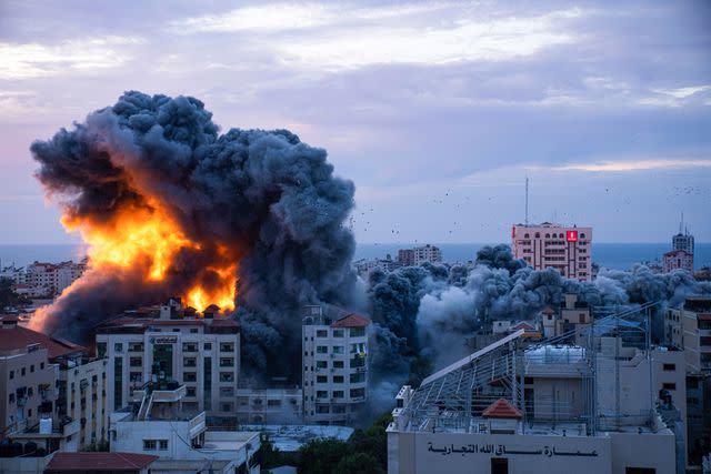 <p>AP Photo/Fatima Shbair</p> Fire and smoke rises following an Israeli airstrike in Gaza City.