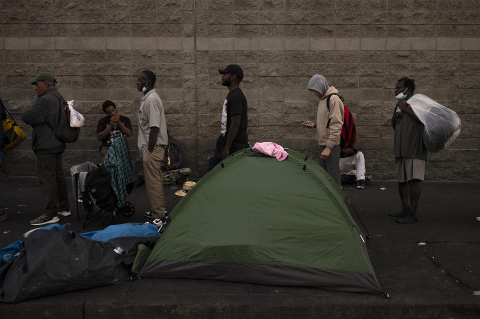 FILE - Homeless people wait in line for dinner outside the Midnight Mission in the Skid Row area of Los Angeles, Wednesday, Oct. 25, 2023. A state audit has found that California spent $24 billion to tackle homelessness over a five year period but didn’t consistently track the outcomes or effectiveness of its programs. The report released Tuesday, April 9, 2024, attempts to assess how effective the state and local cities have been spending billions of dollars to address the ongoing homelessness crisis in California. (AP Photo/Jae C. Hong, File)