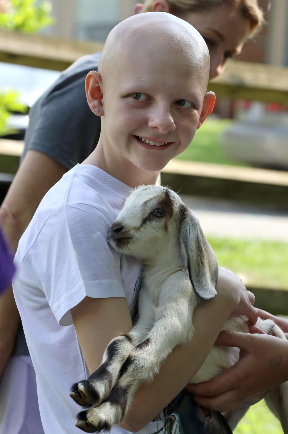 Twelve-year-old Arianna Angle holds a dairy goat at the Sonridge Farm Petting Zoo area during Earth Day at the Gateway Trail held Saturday, April 20, 2024, in Kings Mountain.