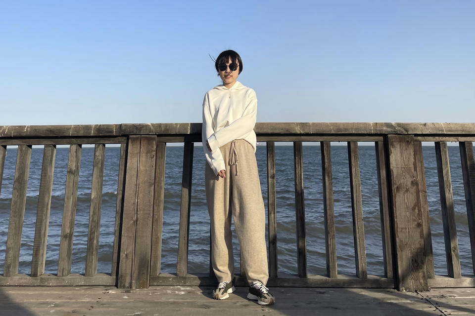 In this April 3, 2021, photo and released by Monica Ma, Monica Ma poses for a photo along the coast of Qinhuangdao in northern China's Hebei province. Ma is among at least 500 students the Chinese government says have been rejected under a policy, aimed at blocking Beijing from obtaining U.S. technology with possible military uses, issued last year by then U.S. President Donald Trump. (Monica Ma via AP)