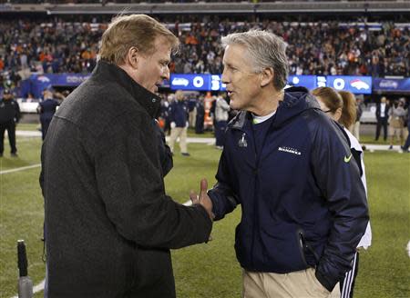 NFL Commissioner Roger Godell (L) shakes hands with Seattle Seahawks head coach Peter Carroll before the NFL Super Bowl XLVIII football game in East Rutherford, New Jersey, February 2, 2014. REUTERS/Carlo Allegri