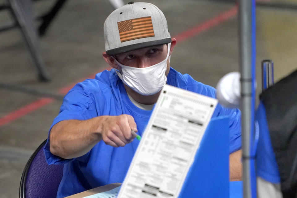 Maricopa County ballots cast in the 2020 general election are examined and recounted by contractors working for Florida-based company, Cyber Ninjas, Thursday, May 6, 2021 at Veterans Memorial Coliseum in Phoenix. The audit, ordered by the Arizona Senate, has the U.S. Department of Justice saying it is concerned about ballot security and potential voter intimidation arising from the unprecedented private recount of the 2020 presidential election results. (AP Photo/Matt York, Pool)