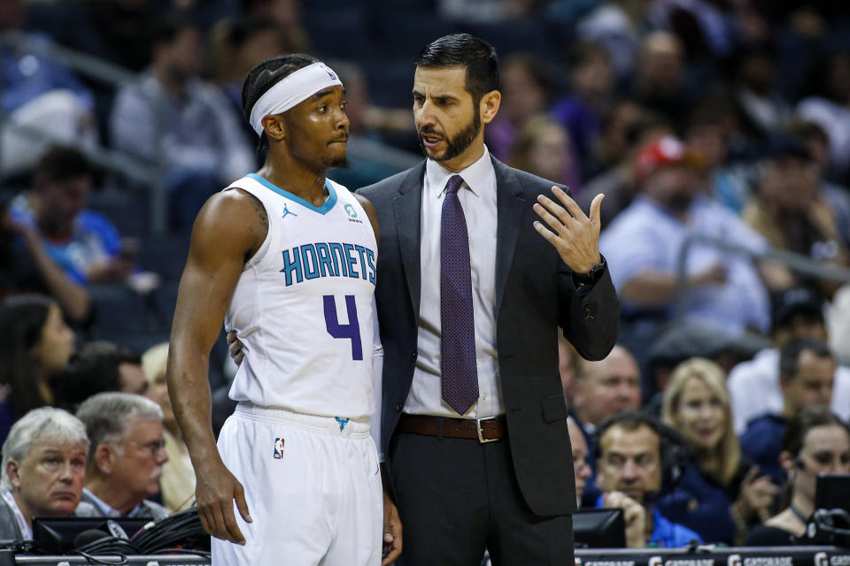 Charlotte Hornets head coach James Borrego, right, talks to Charlotte Hornets guard Devonte' Graham during a break in the action against the Sacramento Kings in the first half of an NBA basketball game in Charlotte, N.C., Tuesday, Dec. 17, 2019. (AP Photo/Nell Redmond)