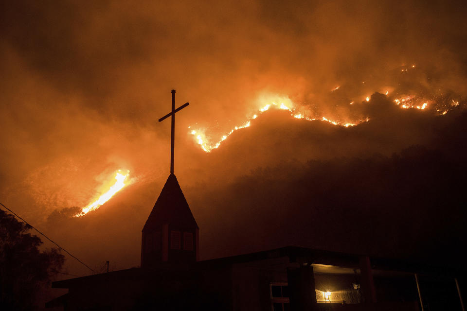 <p>Flames from a wildfire advance down a hillside near the Springs of Life Church in Casitas Springs, Calif., on Tuesday, Dec. 5, 2017. (Photo: Noah Berger/AP) </p>