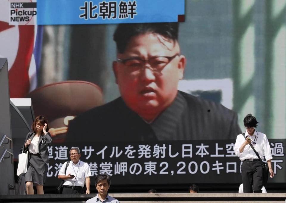 Pedestrians walk under a large-scale monitor displaying North Korean leader Kim Jong-un on a TV news broadcast in Tokyo following a recent missile test (EPA)