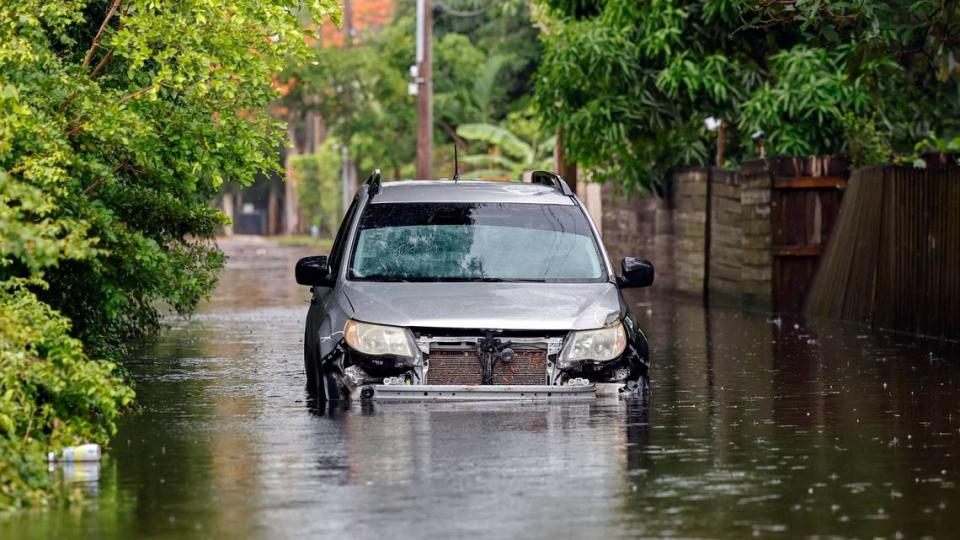 An abandoned vehicle is seen along a flooded street in a residential area of North Miami, Florida, near Northeast 123rd Street on Thursday, June 13, 2024.