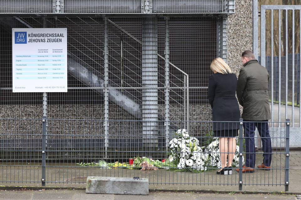 Germany's Interior Minister Nancy Faeser, left, and Hamburg's Senator for the Interior and Sports Andy Grote bow near flowers laid at the site where several people were killed last night, in a rampage during a Jehovah's Witness event, in Hamburg, Germany, Friday March 10, 2023. (Christian Charisius/dpa via AP)