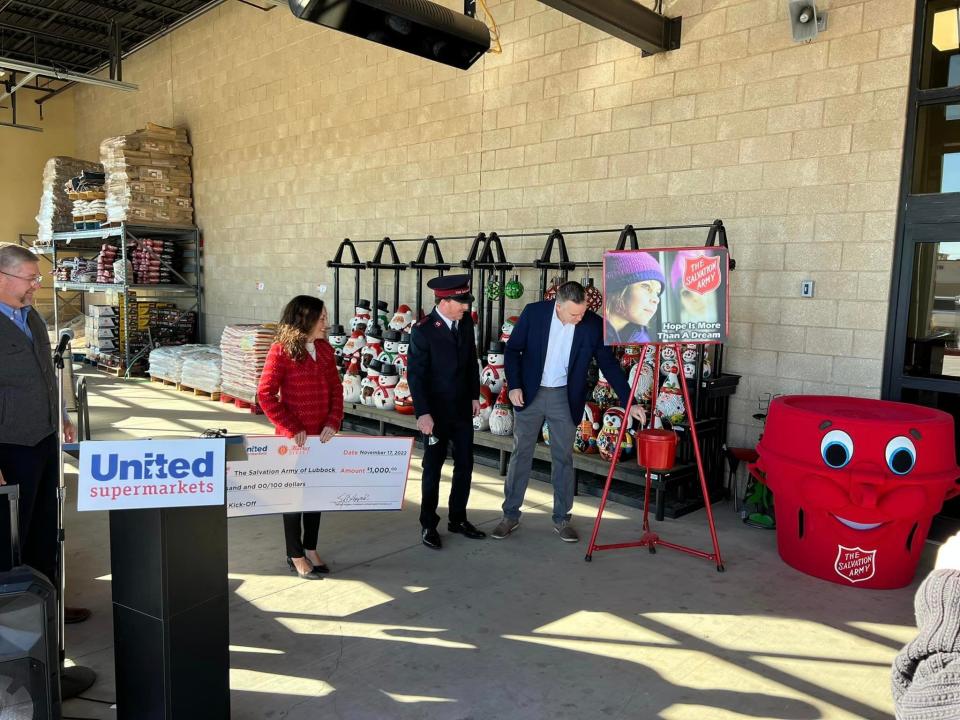 South Plains Salvation Army's Major David Worthy watches Lubbock Mayor Tray Payne contribute to a Red Kettle last week at a Lubbock United store.