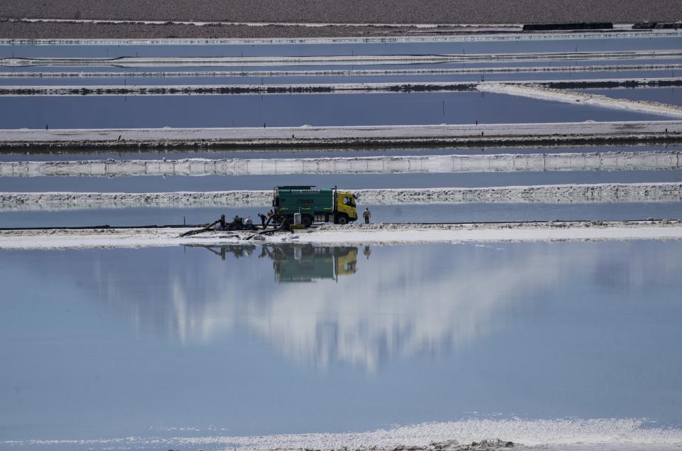 Workers perform maintenance next to pools of brine slowly turning into lithium at the Albemarle lithium mine in Chile's Atacama desert, Monday, April 17, 2023. (AP Photo/Rodrigo Abd)