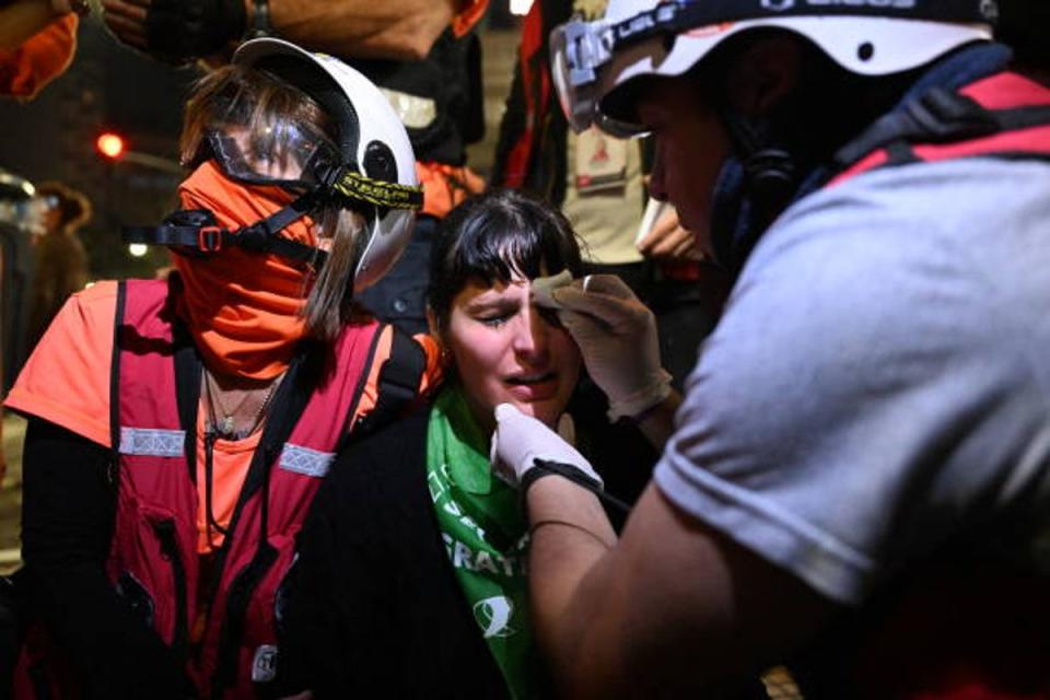 A demonstrator affected by tear gas is assisted during a protest in Buenos Aires on 12 June 2024 (AFP via Getty Images)