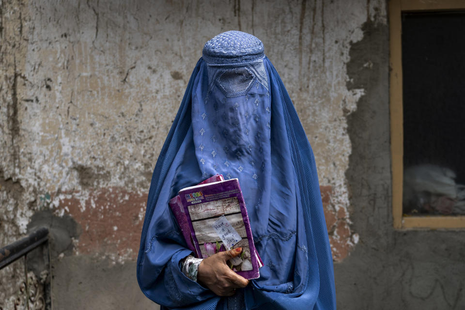 FILE- Arefeh 40-year-old, an Afghan woman leaves an underground school, in Kabul, Afghanistan, Saturday, July 30, 2022. Afghan girls will be allowed to take their high school graduation exams this week, an official and documents from the Taliban government indicated Tuesday, Dec. 6, 2022 even though they have been banned from classrooms since the former insurgents took over the country last year. (AP Photo/Ebrahim Noroozi, File)