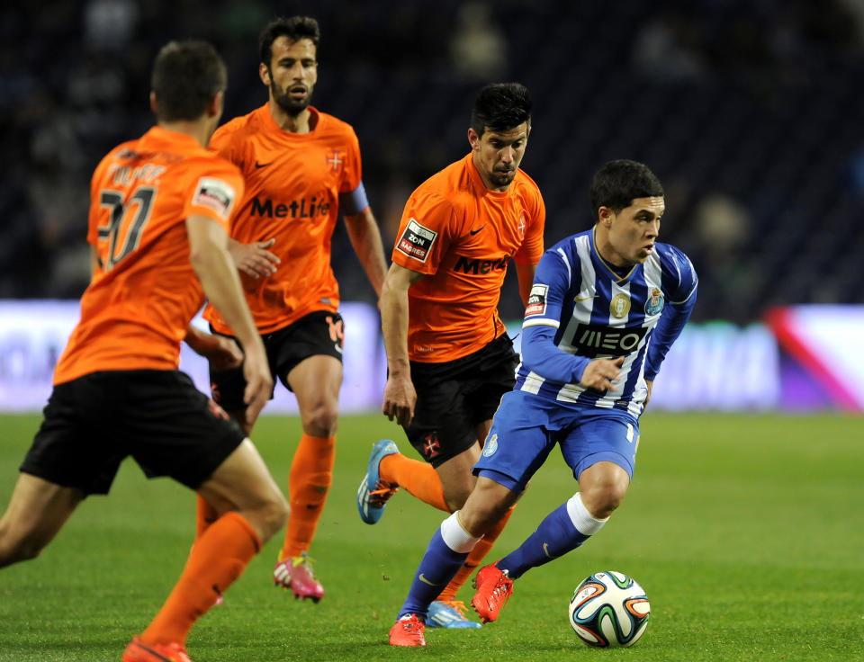 FC Porto's Juan Quintero, from Colombia, drives the ball past Belenenses' Filipe Ferreira, Fernando Ferreira and Miguel Rosa, from left to right, in a Portuguese League soccer match at the Dragao stadium in Porto, Portugal, Sunday, March 23, 2014. Quintero scored the only goal in Porto's 1-0 victory. (AP Photo/Paulo Duarte)