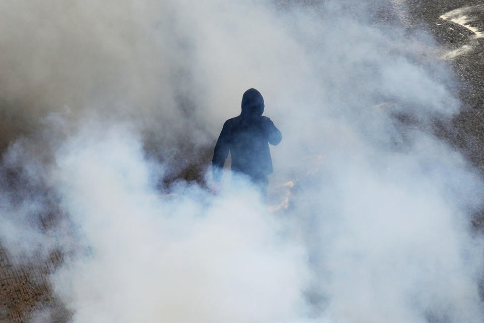 <p>A protester walks among smoke from a tear gas thrown by riot police during clashes at a nationwide general strike demonstration, in Athens Wednesday, May 17, 2017. Greek workers walked off the job across the country Wednesday for an anti-austerity general strike that was disrupting public and private sector services across the country. (AP Photo/Petros Giannakouris) </p>