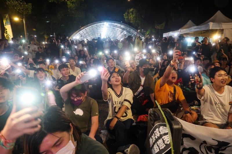 21日晚間青島東路上聚集群眾揮舞手機燈光，齊聲唱起歌曲「島嶼天光」。中央社