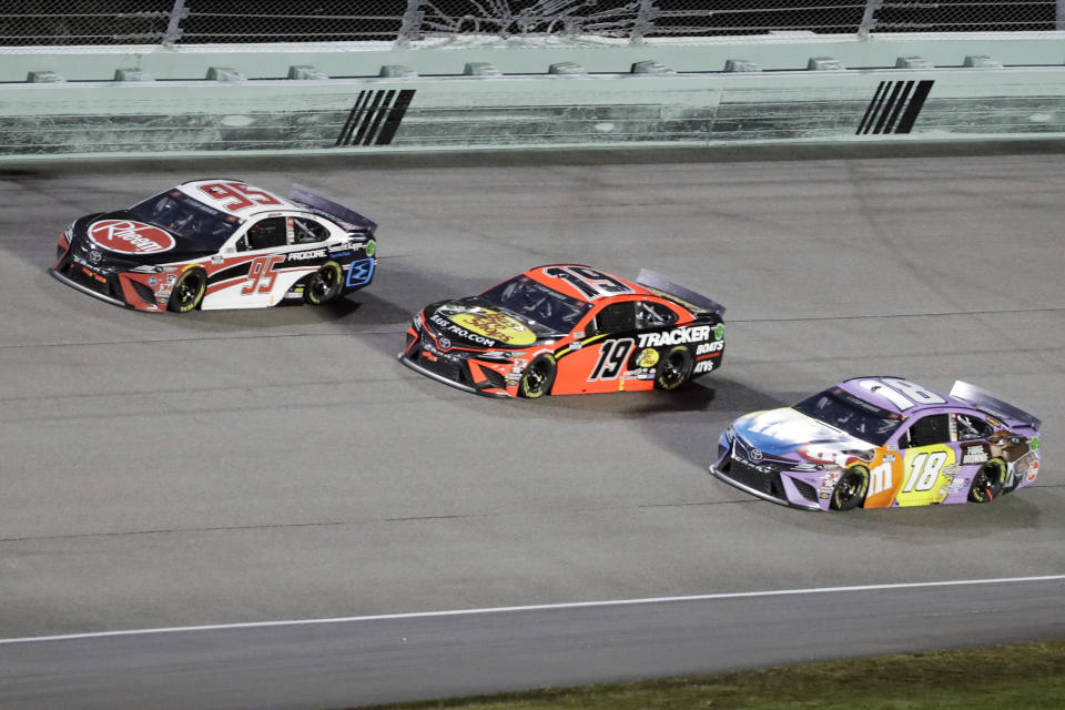 Christopher Bell (95), Martin Truex Jr. (19) and Kyle Busch (18) come through a turn during a NASCAR Cup Series auto race Sunday, June 14, 2020, in Homestead, Fla. (AP Photo/Wilfredo Lee)