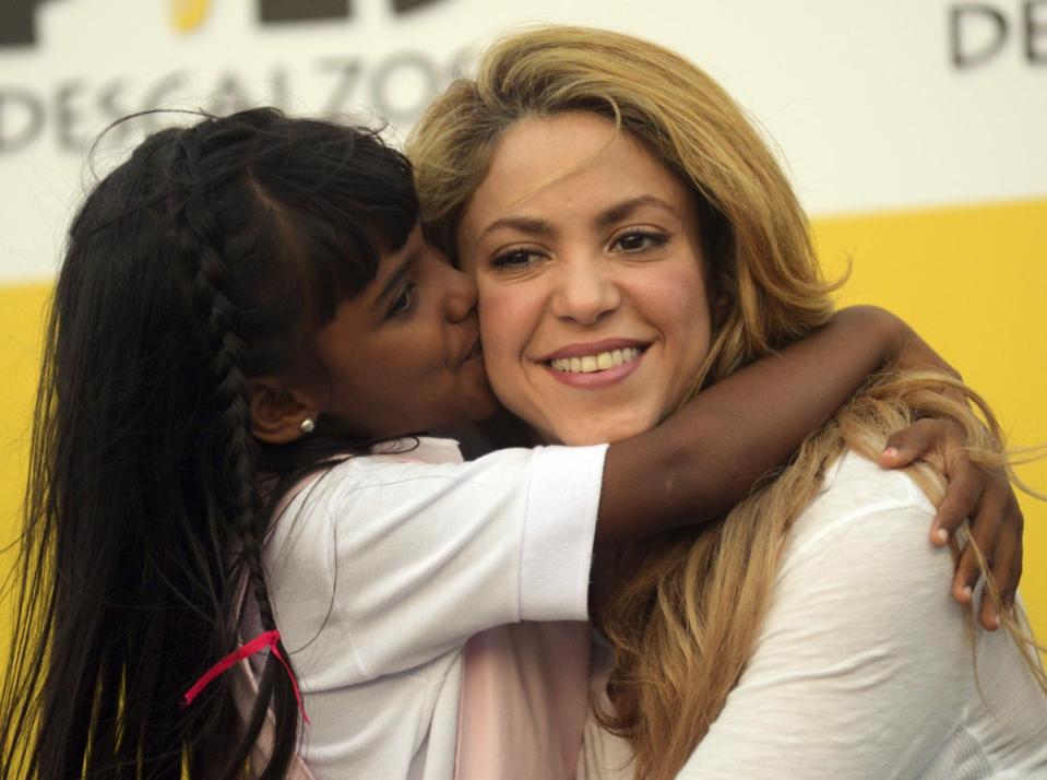 A girl kisses Shakira during the inauguration of a school funded by her foundation, in 2014 (Manuel Pedraza/AFP via Getty Images)