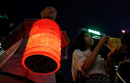 A man holds a traditional lantern as people gather at Lennon Wall at Admiralty district during the Mid-Autumn Festival, in Hong Kong