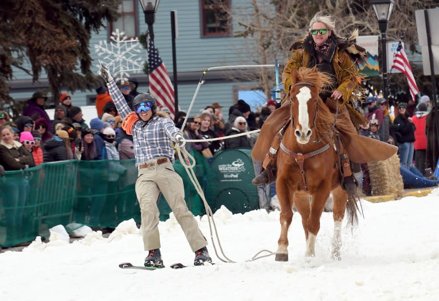 A skijoring team competes in Leadville, Colo., on Saturday, March 2, 2024. Skijoring draws its name from the Norwegian word skikjoring, meaning “ski driving.” It started as a practical mode of transportation in Scandinavia and became popular in the Alps around 1900. Today’s sport features horses at full gallop towing skiers by rope over jumps and around obstacles as they try to lance suspended hoops with a baton, typically a ski pole that’s cut in half. (AP Photo/Thomas Peipert)