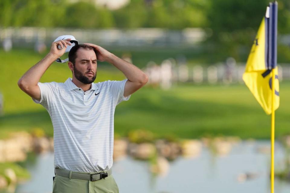 May 16, 2024; Louisville, Kentucky, USA; Scottie Scheffler takes off his hat while lining up a shot on the 18th green during the first round of the PGA Championship golf tournament at Valhalla Golf Club. Mandatory Credit: Jon Durr-USA TODAY Sports