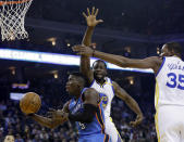 Oklahoma City Thunder's Victor Oladipo (5) drives to the basket as Golden State Warriors' Draymond Green (23) and Kevin Durant (35) defend during the first half of an NBA basketball game Wednesday, Jan. 18, 2017, in Oakland, Calif. (AP Photo/Marcio Jose Sanchez)