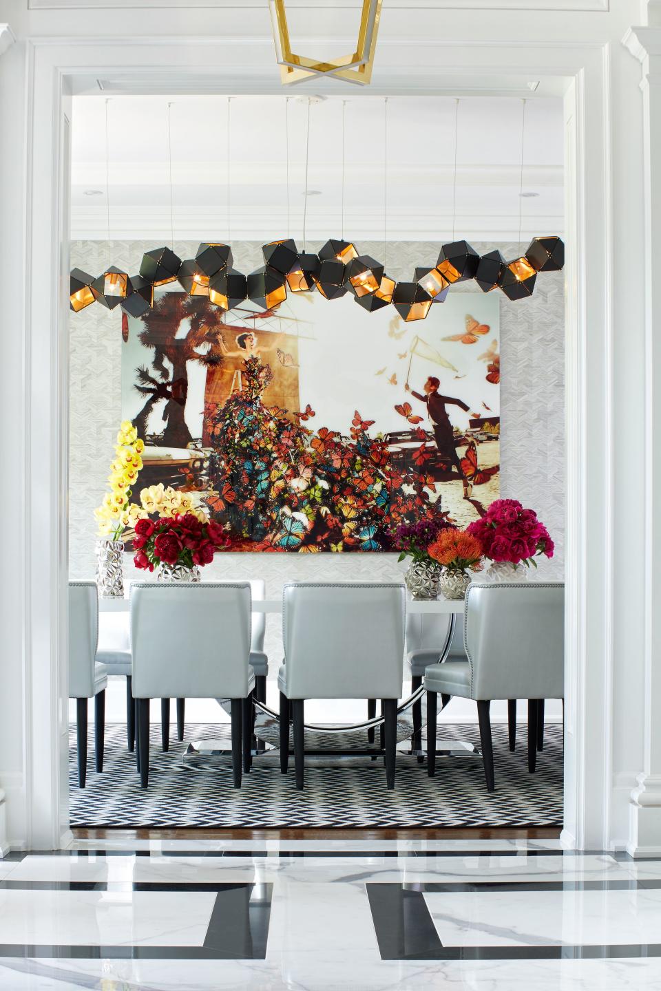 In the dining room, a black steel-and-brass Welles chandelier by Gabriel Scott contrasts boldly with the home’s traditional architecture. Kristian Schuller's Butterfly Catcher takes over the wall, which is covered in grasscloth.