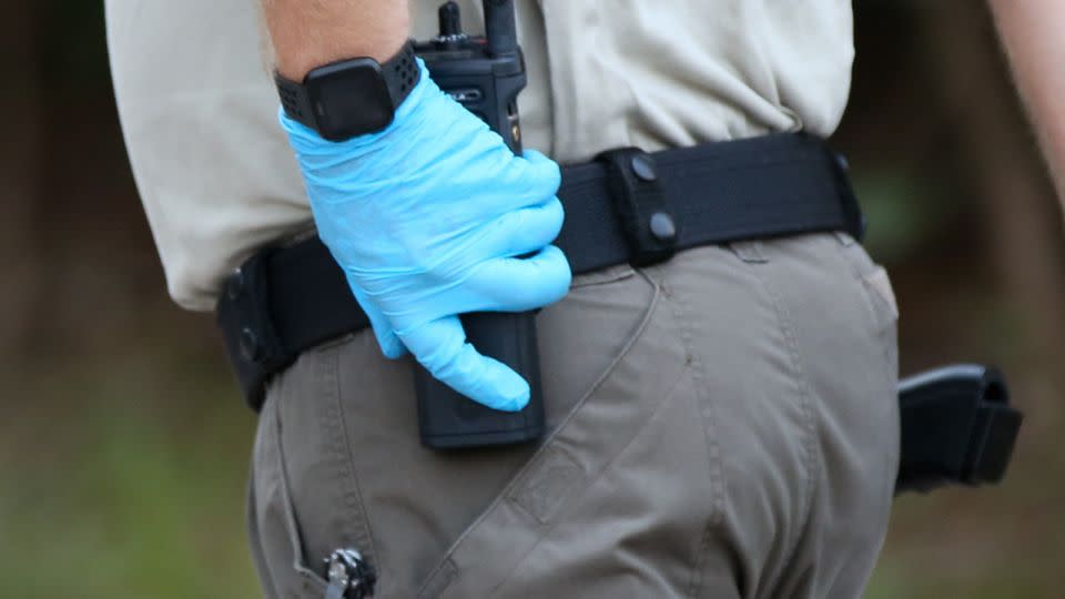 An officer checks his radio following a law enforcement raid related to dog fighting in Orangeburg, South Carolina, on September 21, 2023. - Austin Steele/CNN