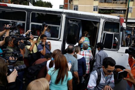 People get into a bus after their polling station was closed and relocated during a nationwide election for new governors in Caracas, Venezuela, October 15, 2017. REUTERS/Carlos Garcia Rawlins