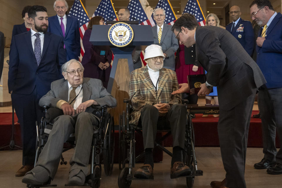 House Speaker Mike Johnson, R-La., right, presents Ghost Army member Bernard Bluestein, of Hoffman Estates, Ill., with a medal during a ceremony to honor members of the secretive WWII-era unit with the Congressional Gold Medal during a ceremony on Capitol Hill, Thursday, March 21, 2024, in Washington. At left is fellow Ghost Army member Seymour Nussenbaum of Monroe Township, N.J. (AP Photo/Mark Schiefelbein)