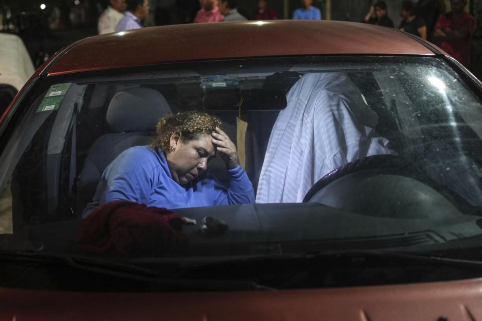 Erika Maria Cruz grieves next to body of her son, Brando Arellano Cruz, fatally shot by police after he failed to pull over, in Lerdo de Tejada near Veracruz, México, Saturday, Jan. 19, 2024. Four municipal police officers are under investigation in relation to the death of the young man, after the victim's neighbors staged violent protests and attempted to lynch the officers. (AP Photo/Felix Marquez)