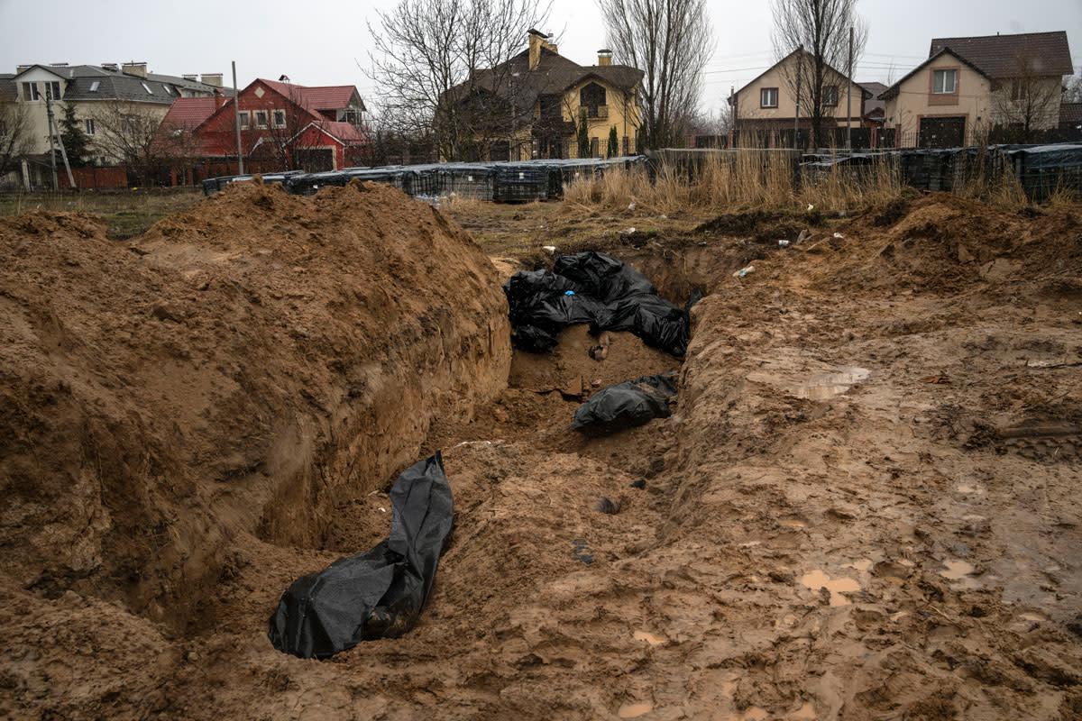 Bodies lie in a mass grave in Bucha, on the outskirts of Kyiv, Ukraine, Sunday, April 3, 2022. 