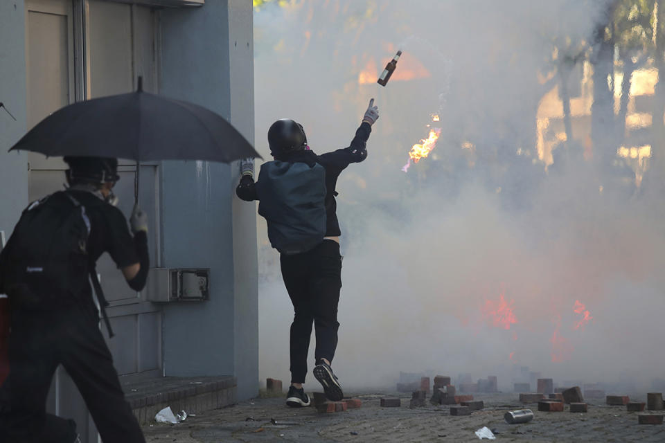 A protestor hurls a molotov cocktail during a confrontation with police at the Hong Kong Polytechnic University in Hong Kong, Sunday, Nov. 17, 2019. Police have fired tear gas at protesters holding out at the Hong Kong Polytechnic University as overnight clashes resumed in the morning. (AP Photo/Kin Cheung)