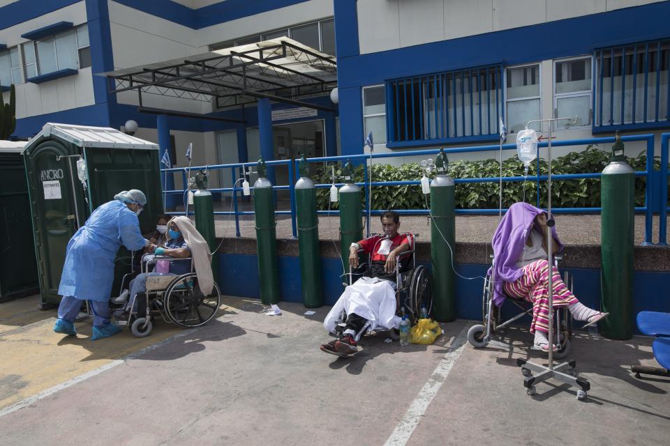 People infected with COVID-19 disease wait for an available bed, outside a public hospital in Lima, Peru, Thursday, April 30, 2020. (AP Photo/Rodrigo Abd)