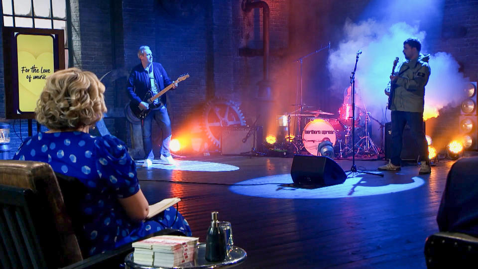 Dragons watch a band performance at the start of a pitch. (BBC)