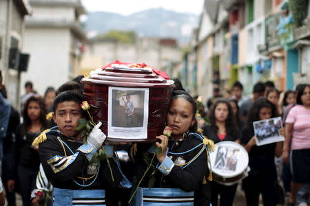 Bandmates participate in the funeral of Bryan Sandoval, a mudslide victim in Santa Catarina Pinula, on the outskirts of Guatemala City, October 4, 2015. Seven members of the Sandoval family were buried together after their bodies were found following a landslide that swallowed part of a Guatemalan town. Rescue teams have found more than 120 bodies and up to 300 others are missing and feared dead. REUTERS/Jose Cabezas