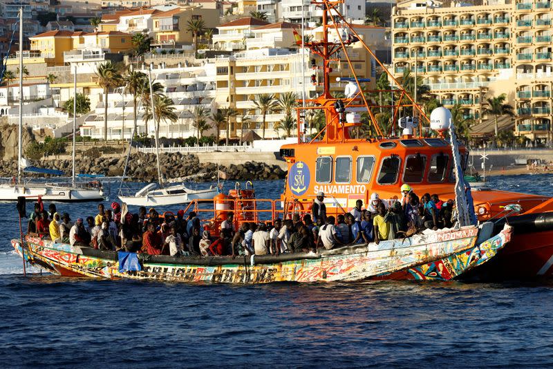 Group of migrants in a wooden boat are towed by a Spanish coast guard vessel to the port of Arguineguin