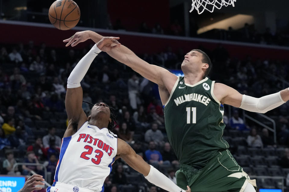 Milwaukee Bucks center Brook Lopez (11) knocks the ball away from Detroit Pistons guard Jaden Ivey (23) during the second half of an NBA basketball game, Monday, March 27, 2023, in Detroit. (AP Photo/Carlos Osorio)