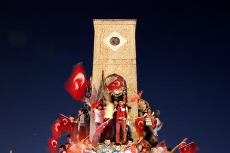 Supporters of Turkish President Tayyip Erdogan wave Turkish national flags and shout slogans as they stand around the Republic Monument in Taksim Square in Istanbul, Turkey, July 16, 2016. REUTERS/Alkis Konstantinidis