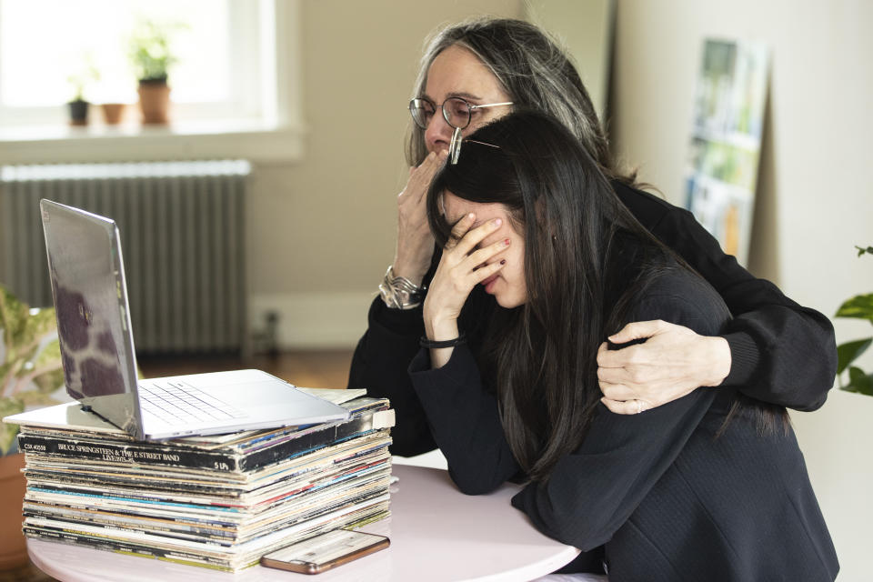 FILE - In this April 29, 2020, file photo, Beth Pardo and her daughter Zoe Ko view a burial service for Winifred Pardo via video conference, in Orefield, Pa. When 91-year-old Pardo died at last month, her family was in other states and couldn't be with her because of the coronavirus. (AP Photo/Matt Rourke, File)