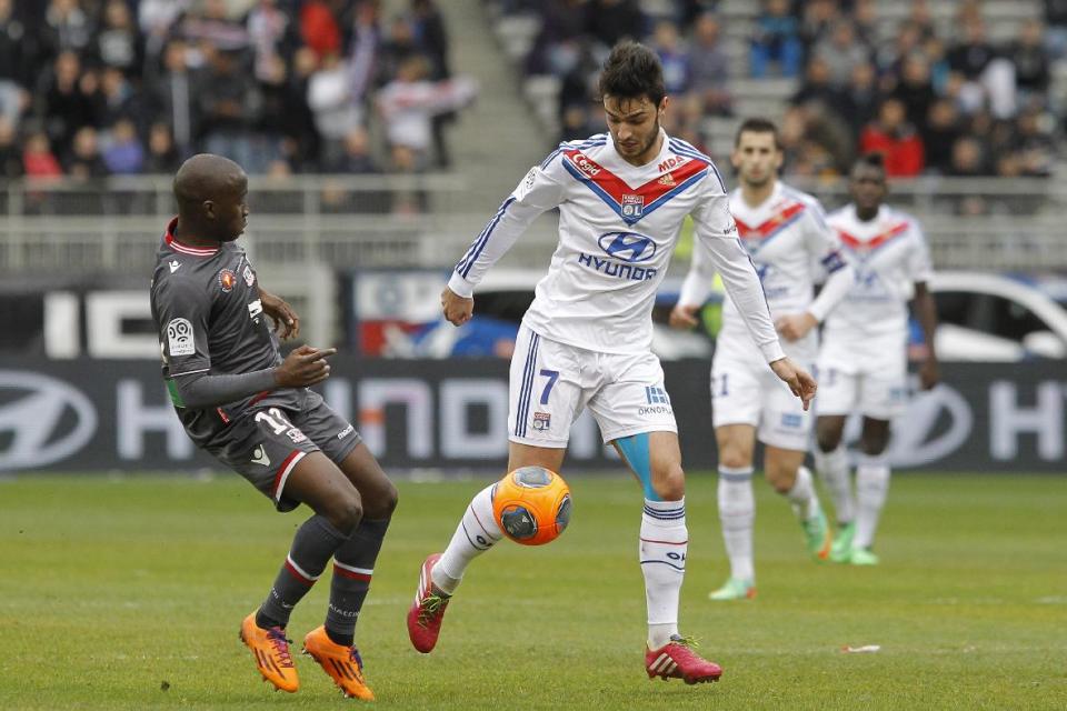 Lyon's Clement Grenier, right, challenges for the ball with Ajaccio's Sigamary Diarra, left, during their French League One soccer match at Gerland stadium, in Lyon, central France, Sunday, Feb. 16, 2014. (AP Photo/Laurent Cipriani)