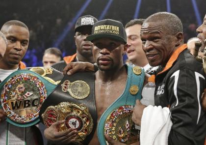 Floyd Mayweather Jr. poses with his champion&#39;s belts and his father Floyd Mayweather Sr. (AP)