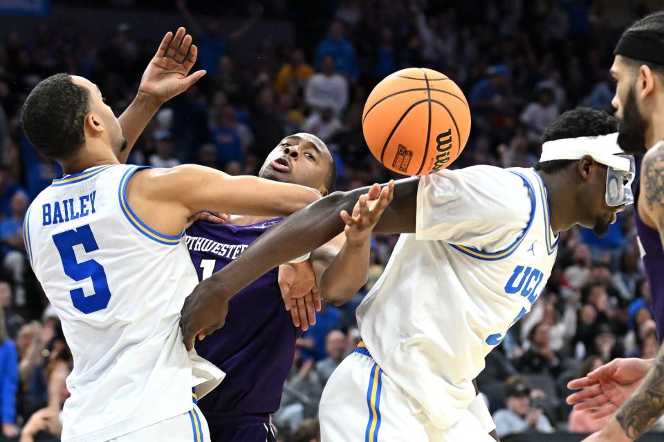 Sacramento California March 16, 2023-UCLA's Ammari Bailey, left, and Adem Bona battle for loose ball.