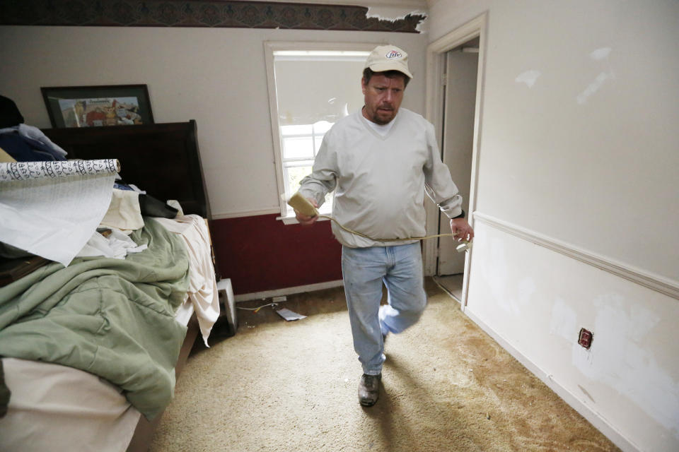 Chris Sharp, a northeast Jackson, Miss., resident who experienced the previous Pearl River flooding of 1979 and 1983, moves quickly in his house to find where and how high the water had accumulated Wednesday, Feb. 19, 2020. (AP Photo/Rogelio V. Solis)