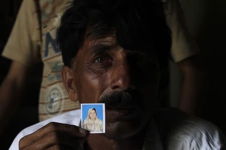 Muhammed Iqbal, 45, shows a picture of his late wife Farzana Iqbal, at his residence in a village in Moza Sial, west of Lahore May 30, 2014. REUTERS/Mohsin Raza