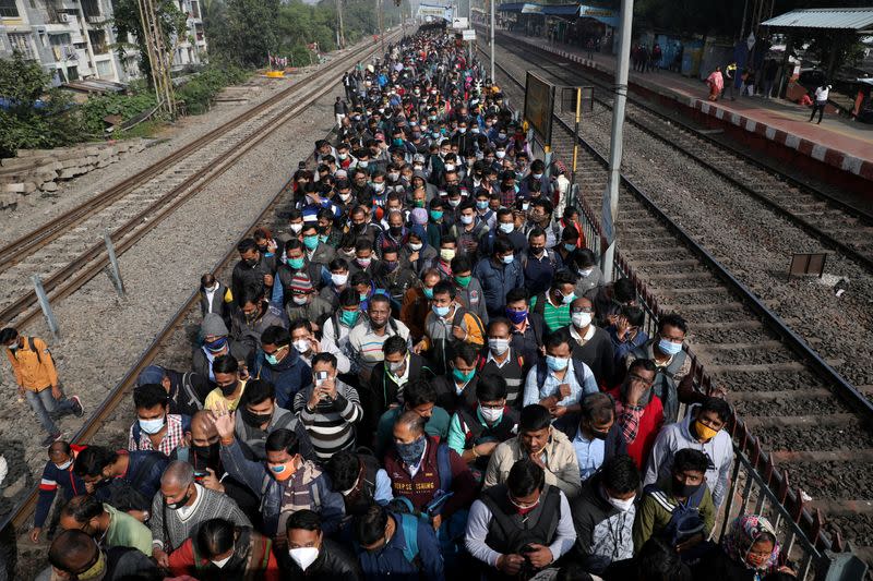 FILE PHOTO: Commuters leave a platform after disembarking from a suburban train on the outskirts of Kolkata