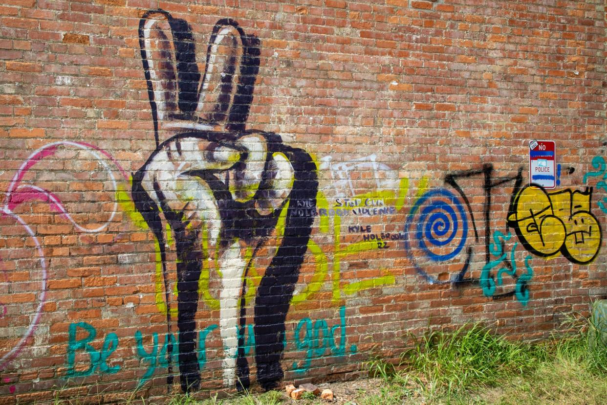 Kyle Holbrook, 44, completed this mural of a peace sign on Saturday, July 30, to raise awareness about gun violence and provide a memorial for victims' families.