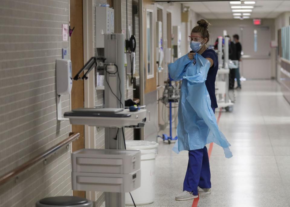 A nurse puts on a protective gown before entering a patient's room on the sixth floor COVID wing on Aug. 19, 2021, at Marshfield Medical Center in Marshfield. Marshfield Clinic Health System, as well as other health systems in the state, are bracing for a very severe flu season as well as a continuing prevalence of COVID-19 and increasing cases of RSV.