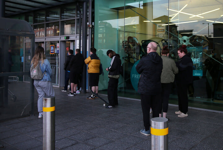 Customers queuing outside an Aldi store