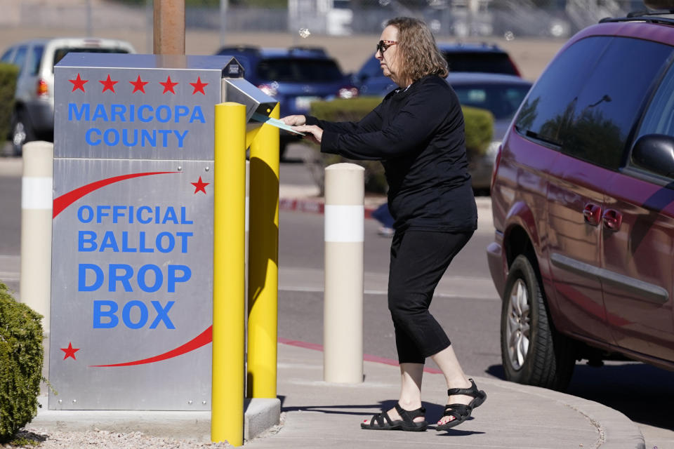 FILE - A voter places a ballot in an election voting drop box in Mesa, Ariz., Oct. 28, 2022. According to a bipartisan report released Tuesday, Feb. 6, 2024, that calls for greater transparency and steps to make voting easier, a “tumultuous period of domestic unrest” combined with a complicated and highly decentralized election system has led to a loss of faith in election results among some in the U.S. (AP Photo/Ross D. Franklin, File)