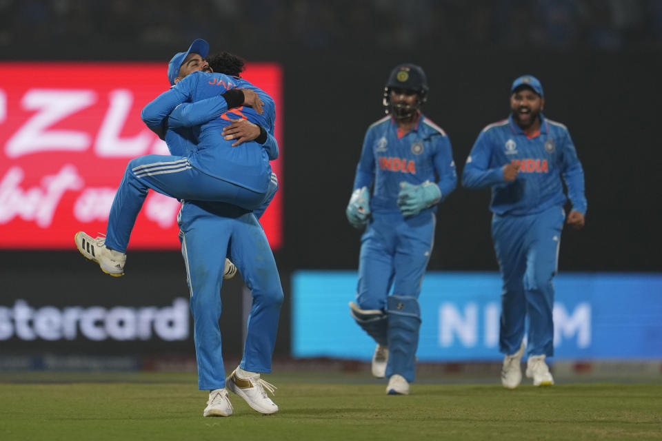 India's Ravindra Jadeja hugs teammate Virat Kohli, left, to celebrate the dismissal of South Africa's captain Temba Bavuma during the ICC Men's Cricket World Cup match between India and South Africa in Kolkata, India, Sunday, Nov. 5, 2023. (AP Photo/Altaf Qadri)