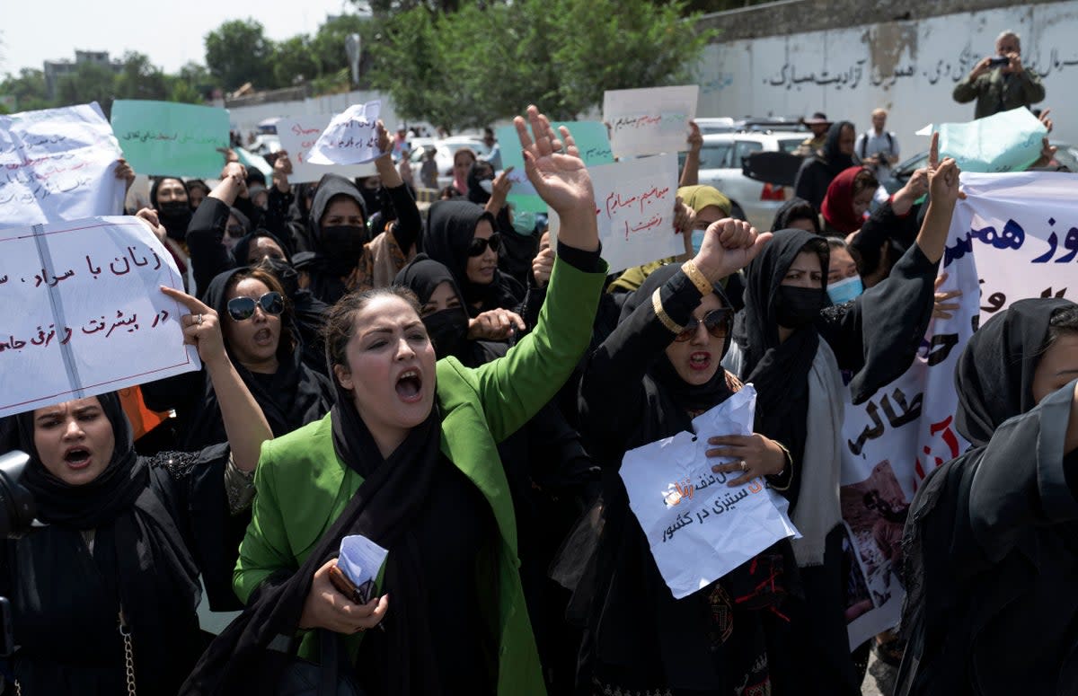 Afghan women hold placards during a women’s rights protest in Kabul on 13 August (AFP via Getty)